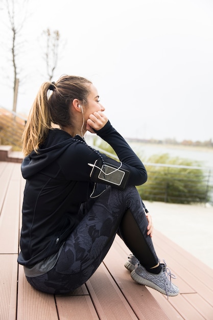 Femme sportive frustrée et fatiguée, assise en plein air dans les escaliers