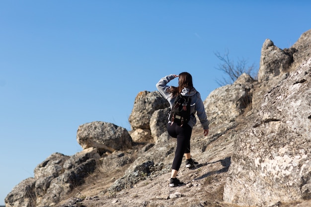 femme sportive grimpe au sommet de la montagne de la falaise avec un ciel bleu