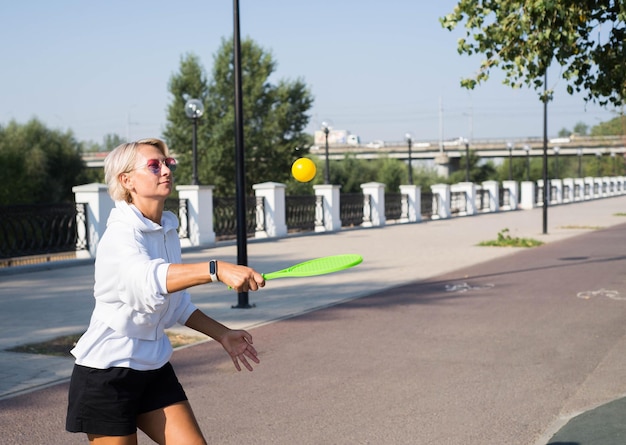 Une femme sportive joue au tennis en plein air