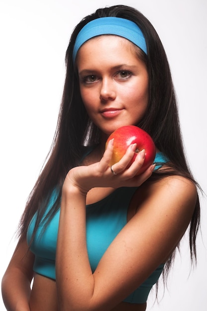 Femme sportive mordant une pomme rouge