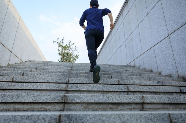 Une femme sportive qui monte les escaliers en ville.