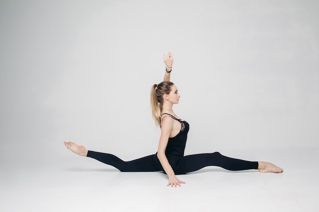 Femme sportive s'entraînant, assise dans une ficelle longtudinale.