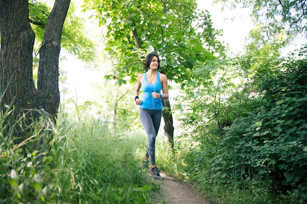 Femme sportive souriante qui court à l'extérieur