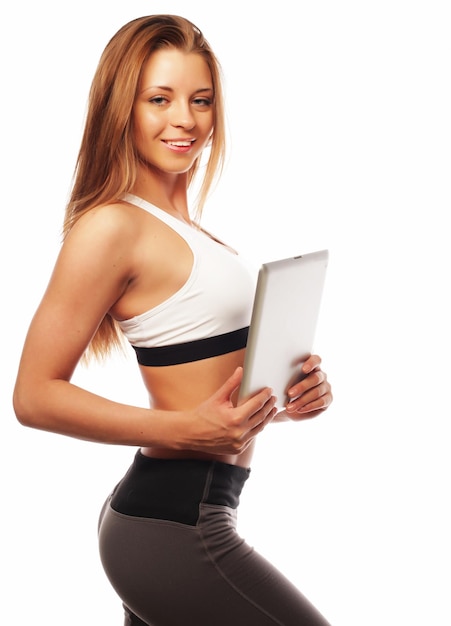 Femme sportive souriante avec une tablette vierge