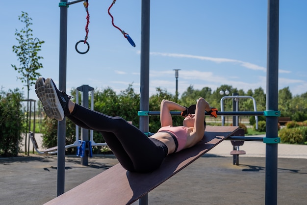 Femme sportive travaillant sur le terrain de sport en journée d'été ensoleillée