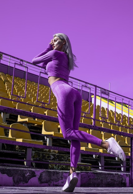 Femme sportive en vêtements de sport femme sexy sur le stade gymnase entraîneur féminin entraînement yoga entraîneur sport succès parfait forme du corps fitness sport mode régime sain dame a le cul serré