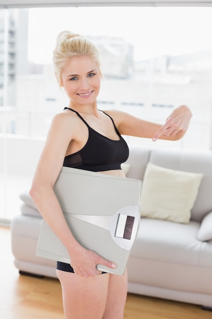 Femme en sportswear portant échelle dans un studio de remise en forme