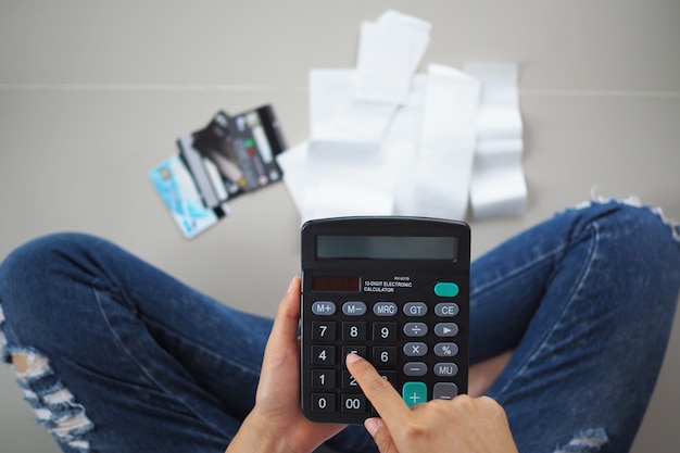 Femme stressée calculant les dépenses de recettes