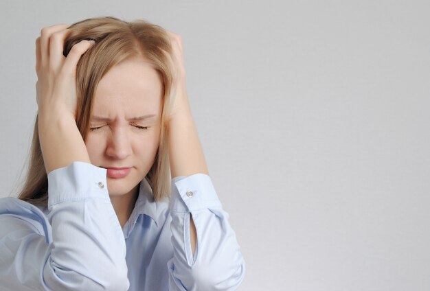 Femme stressée avec mal de tête tient sa tête