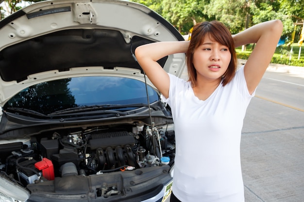 femme stressée à la recherche de quelqu&#39;un aide à l&#39;ouverture de capot de voiture