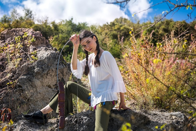 Femme de style en tant que peuples autochtones d'Amérique avec un arc et une flèche