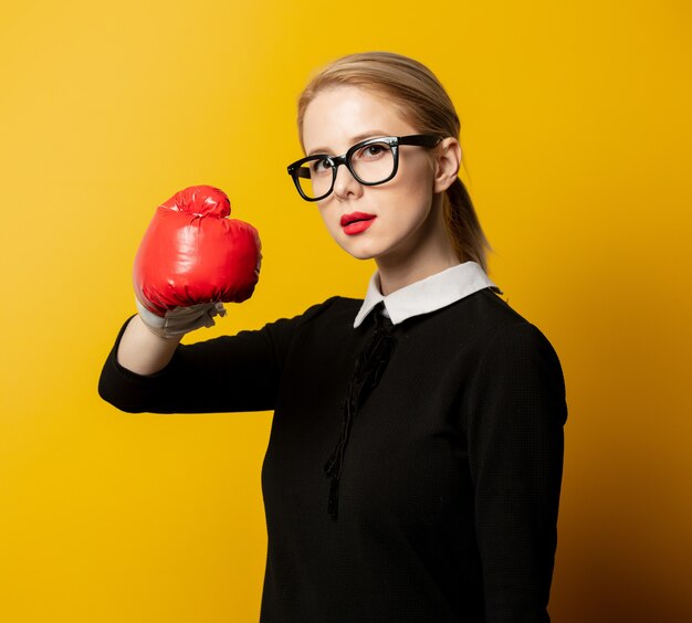 Femme de style en vêtements formels noirs avec gant de boxe