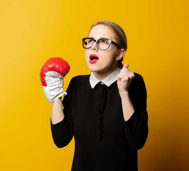 Femme de style en vêtements formels noirs avec gant de boxe