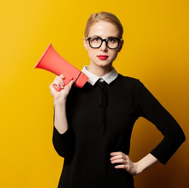 Femme de style en vêtements formels noirs avec mégaphone