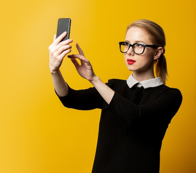 Femme de style en vêtements formels noirs avec téléphone portable