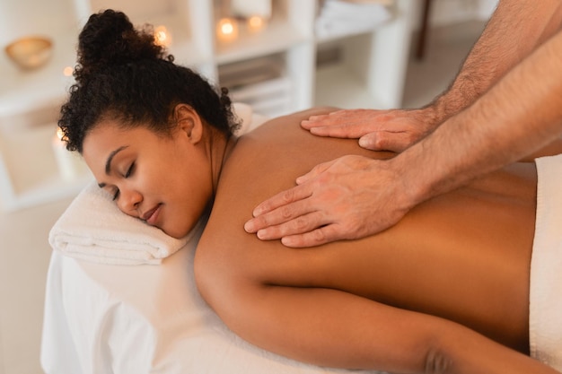 Une femme subit un massage du dos au spa.