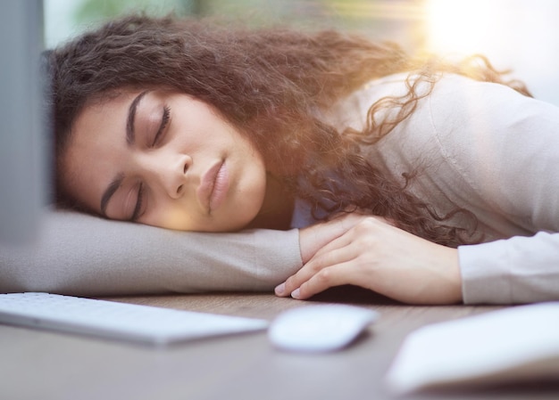 Femme surmenée fatiguée se reposant sur le lieu de travail au bureau