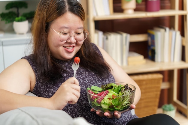 Femme en surpoids asiatique à régime Perte de poids Manger de la salade fraîche fraîche faite maison Concept d'alimentation saine Femme obèse avec mode de vie de régime de poids