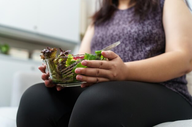 Femme en surpoids asiatique à régime Perte de poids Manger de la salade fraîche fraîche faite maison Concept d'alimentation saine Femme obèse avec mode de vie de régime de poids