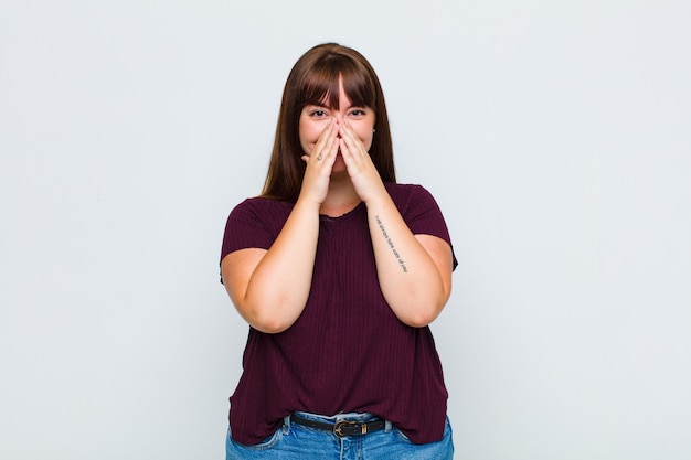 Femme en surpoids à la bouche heureuse, joyeuse, chanceuse et surprise couvrant les deux mains