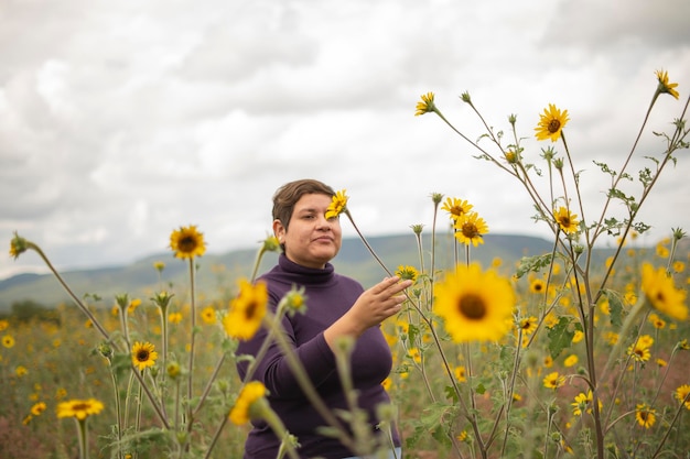 Femme en surpoids dans un champ de fleurs jaunes