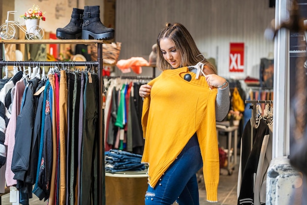 Femme en surpoids essayant des vêtements dans un magasin de vêtements dans la section taille plus
