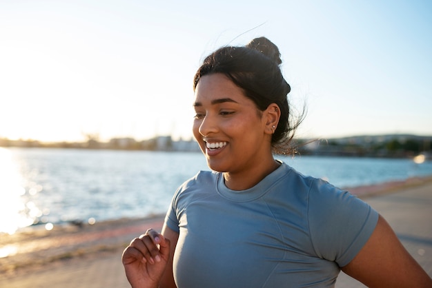 Photo femme en surpoids faisant de l'exercice à l'extérieur au bord du lac