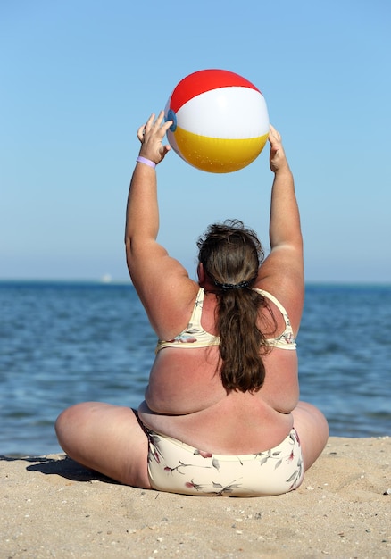 Femme en surpoids faisant de la gymnastique sur la plage