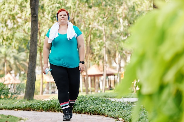 Femme en surpoids qui marche dans le parc