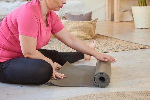 Femme en surpoids se préparant pour le yoga à la maison mode de vie sain