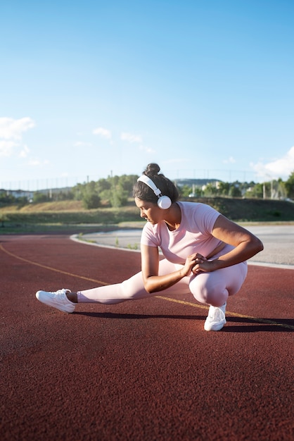 Femme en surpoids travaillant tout en écoutant de la musique sur des écouteurs