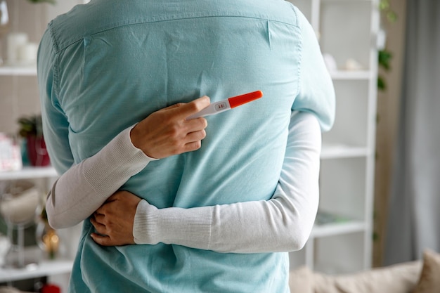 Femme surprenant son mari avec un test de grossesse positif