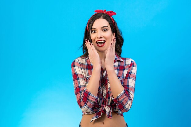 La femme surprise debout sur le fond bleu