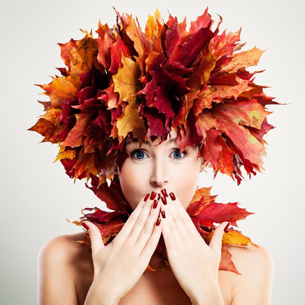 Photo femme surprise avec des feuilles d'automne. surprise et amusement