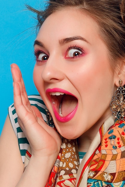 Femme surprise sur un mur bleu.