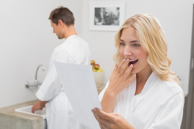 Femme surprise en regardant document avec un homme dans la cuisine