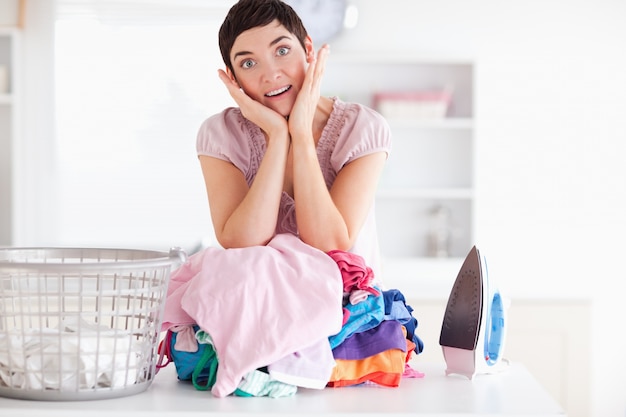 Femme surprise avec un tas de vêtements