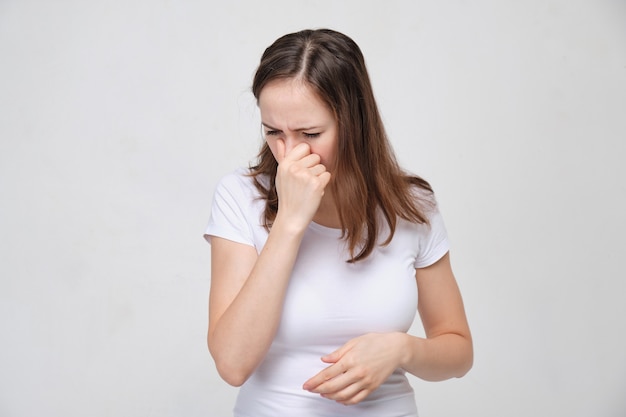 femme en T-shirt blanc a du mal à respirer par le nez.