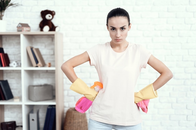 Une femme en T-shirt blanc à la maison avec des fonds pour le nettoyage.