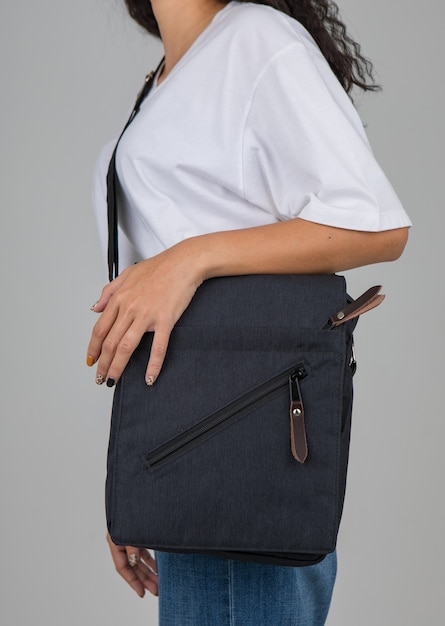Une femme en t-shirt blanc porte le sac décontracté sur l'épaule avec un geste actif et facile.
