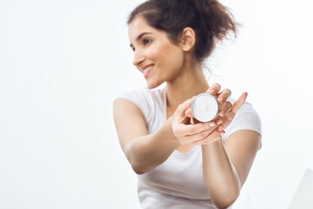 Femme en t-shirt blanc pot de crème soins de la peau dermatologie hydratante photo de haute qualité