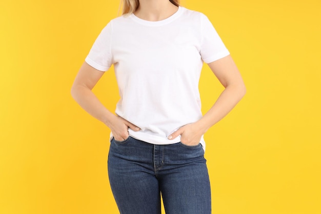 Femme en t-shirt blanc vierge sur fond jaune