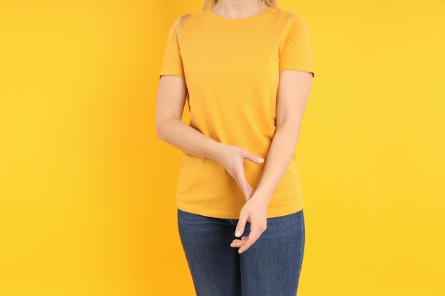 Femme en t-shirt orange vierge sur fond jaune