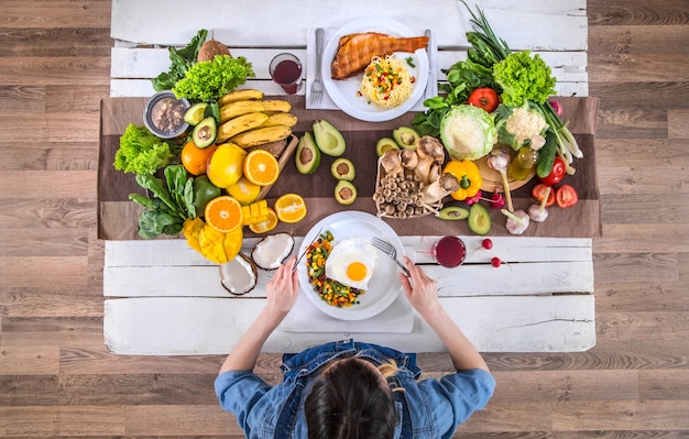 La femme à la table du dîner avec des aliments biologiques, la vue d'en haut.