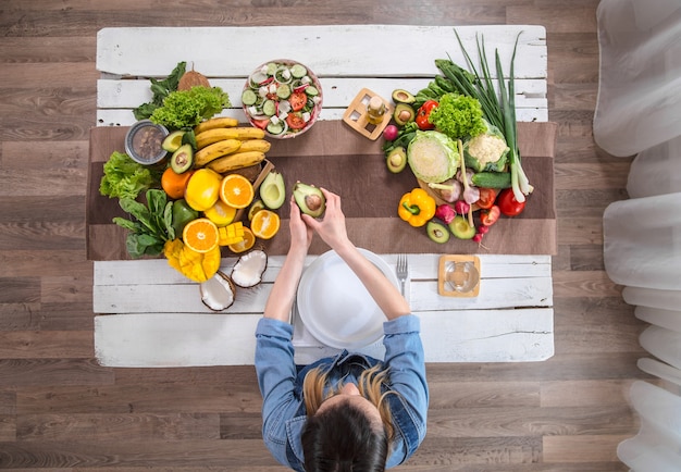 La femme à la table du dîner avec des aliments biologiques, la vue d'en haut.