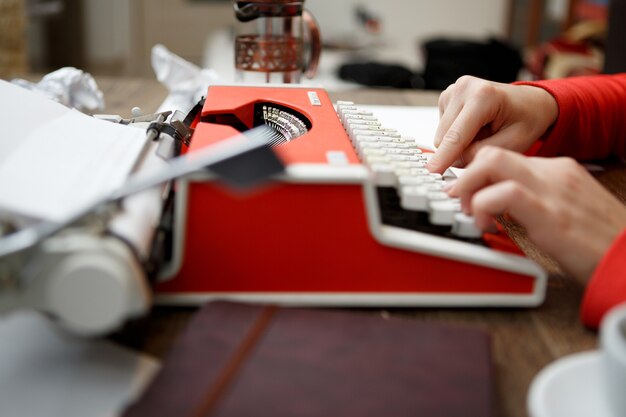 Femme à table en tapant sur machine à écrire