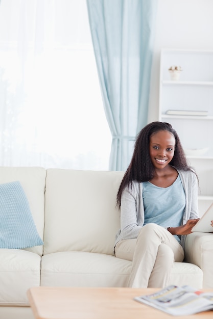 Femme avec une tablette sur le canapé