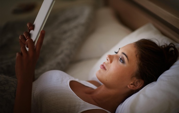 Photo femme tablette et lit la nuit défilement et divertissement avec la technologie et relaxation pour la paix avant le sommeil femme personne navigation et en ligne pour internet à domicile et e-learning ou les médias sociaux