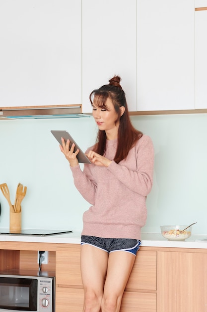 Femme avec tablette numérique dans la cuisine