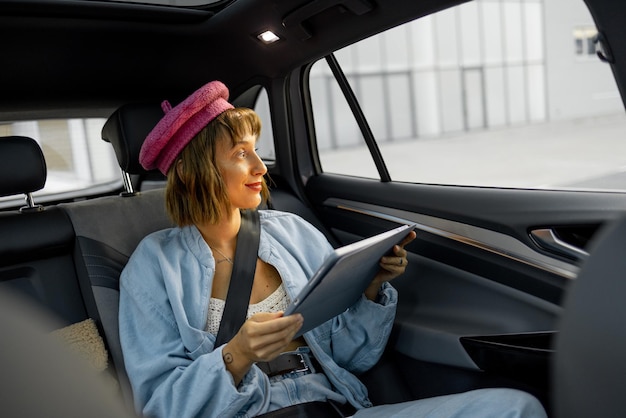 Photo femme avec une tablette numérique dans la voiture